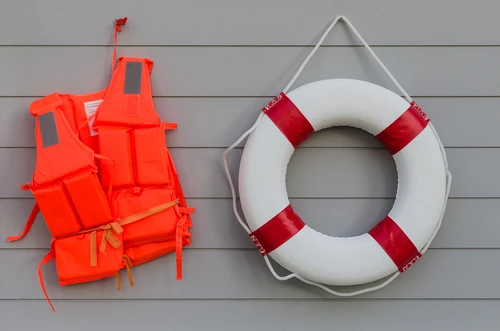 Pool safety equipment including life jackets and a life ring at a rental property