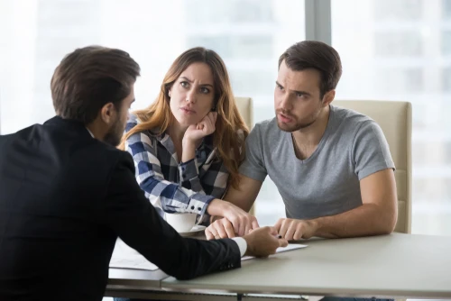 Prospective tenants discussing questions and concerns with a property manager during a rental meeting.