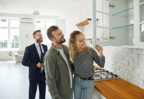 Prospective renters touring a rental property in person with a property manager.