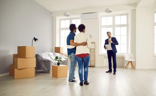 Couple touring a rental property with a property manager during an apartment viewing.