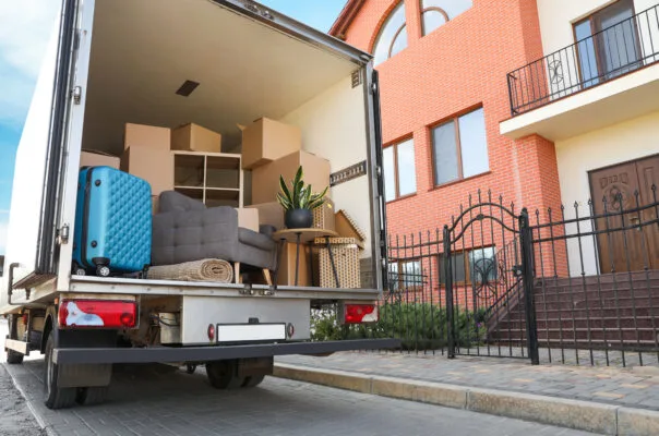 Moving truck loaded with furniture and boxes in front of a new home, ready for renter move-in.