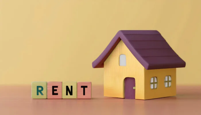 A brightly colored toy house next to the word 