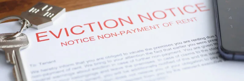 Document on eviction from housing for non-payment lies on table with keys.