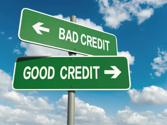 A sign pointing towards bad credit and a sign pointing towards good credit