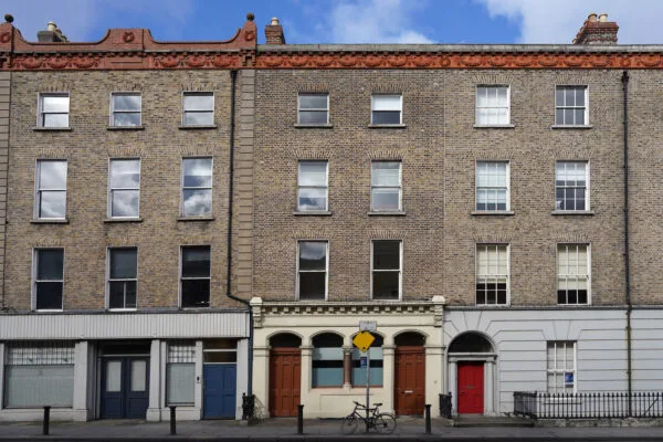 Facades of old brick apartment buildings with ornate roof moulding