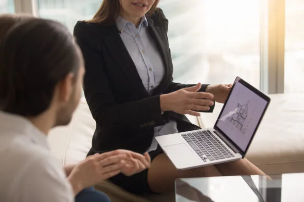 Property manager discussing lease extension options with tenants using a laptop