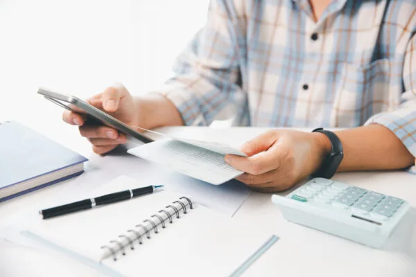 Person reviewing lease extension documents with calculator and phone