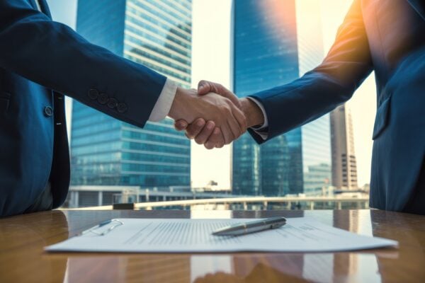 Investors shaking hands over a property contract, symbolizing when to use ROFR or ROFO in real estate deals
