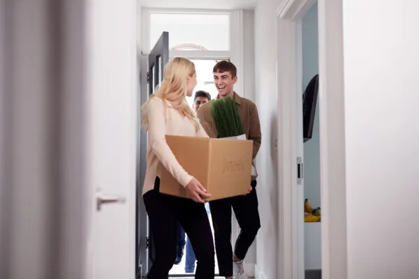Happy tenants moving into a rental property with boxes, representing the impact of rental concessions.