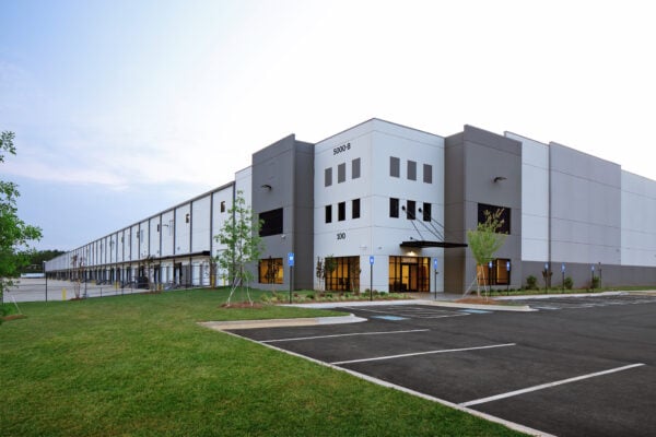 Modern gray industrial warehouse distribution building and parking