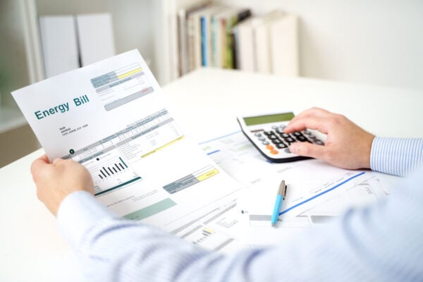 Man calculating home electricity expenses and bill statement document