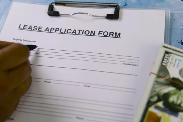 Tenant filling out a lease application form during apartment rental screening
