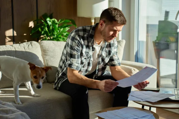 Tenant reviewing lease documents with dog in apartment
