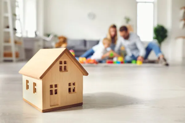 family relaxing in a modern rental home with house model in foreground