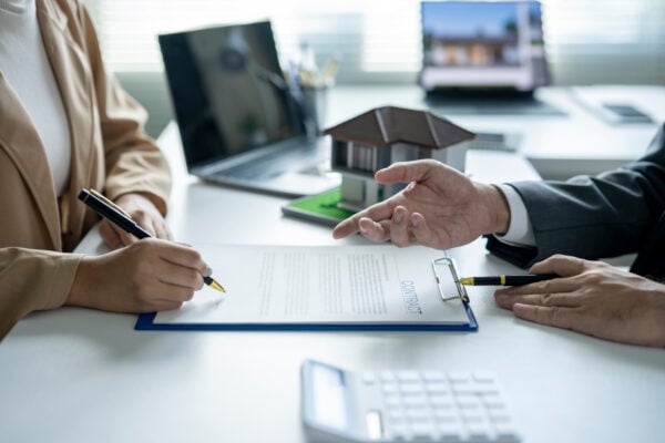 Property manager explaining lease agreement to tenant before signing