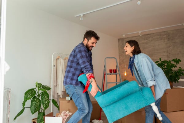 Couple moving furniture into apartment while starting a new rental