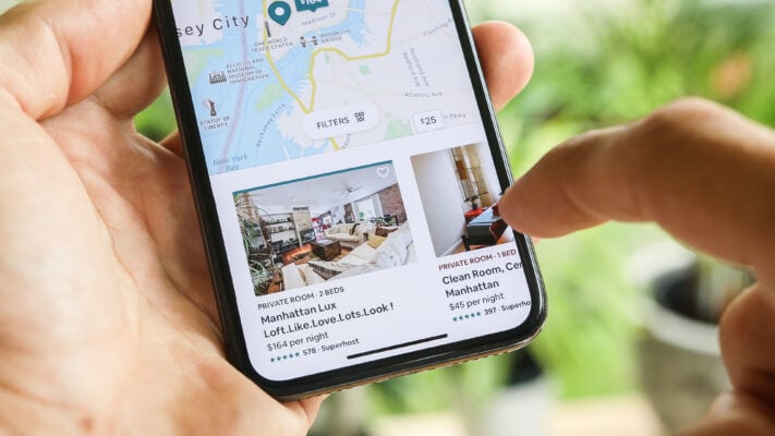 Person browsing rental property listings on a smartphone app