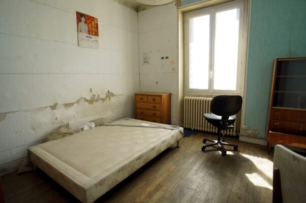 partially vacated apartment with mattress and minimal furniture left behind