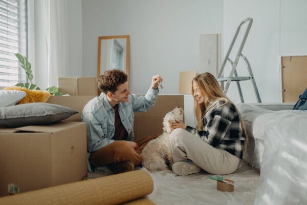 Couple moving into a new apartment with their dog and unpacking boxes