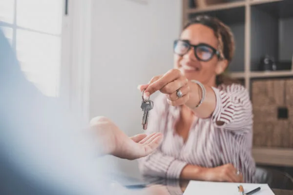 Property owner handing keys to a tenant for a rental unit