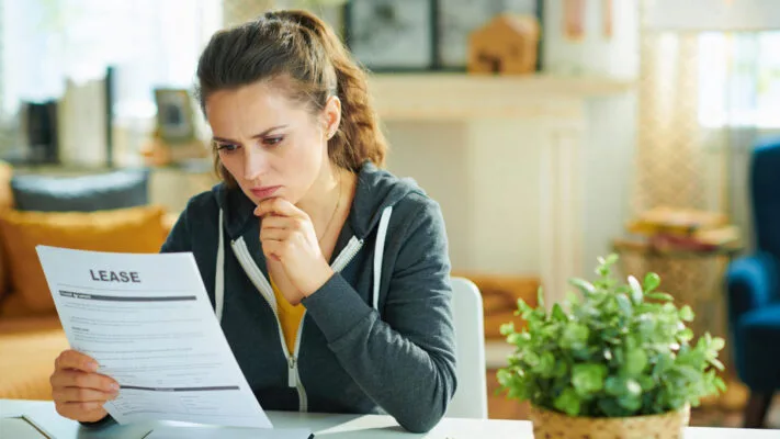 Person reviewing a lease agreement before starting the eviction process