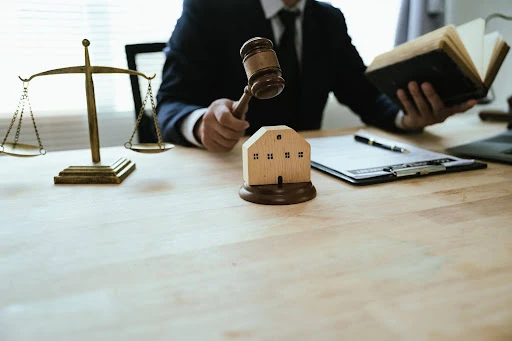Legal documents and a house model representing tenant screening laws for landlords.