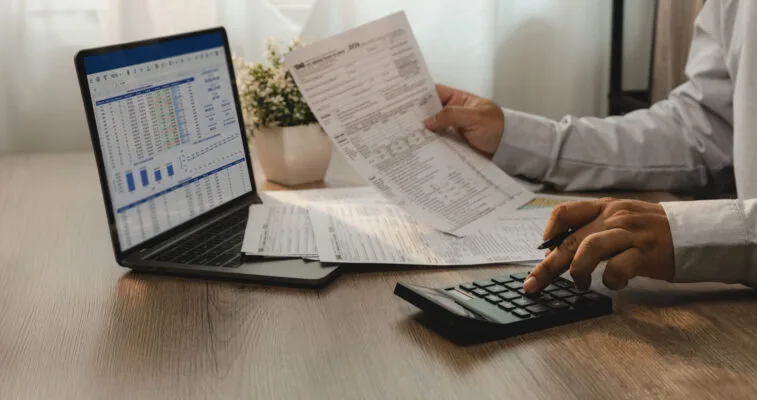 Property owner using a calculator to review property management costs and expenses