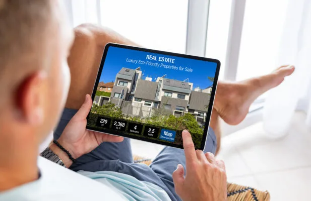 Real estate investor searching online property listings in a potential rental market